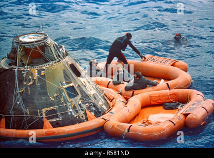 (9 febbraio 1971) --- l'Apollo 14 equipaggi sedersi in una zattera di salvataggio accanto alla loro modulo di comando (CM) nell'Oceano Pacifico del sud come essi attendono una U.S. Navy elicottero, che li porterà a bordo della USS New Orleans, adescare il recupero della nave. L'equipaggio di uomini sono, da sinistra a destra, gli astronauti Alan B.Shepard Jr., comandante; Stuart A. Roosa, il pilota del modulo di comando; e D. Edgar Mitchell, modulo lunare pilota. Foto Stock