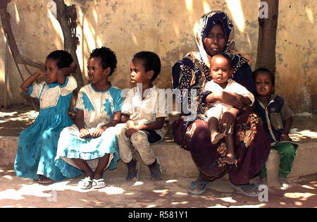 1993 - diritto sul colpo di cinque bambini somali e un somalo donna come loro siedono su un cordolo aspettando pazientemente il loro turno per vedere US Navy medici conducendo un medico civile Programma d'azione nella capitale Mogadiscio, Somalia. Foto Stock