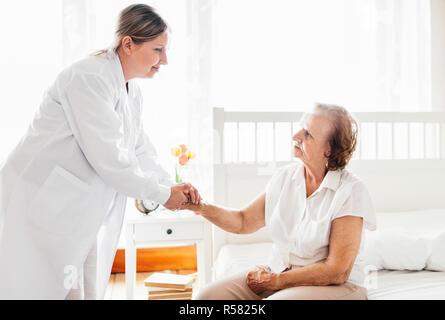 Fornire la cura per gli anziani. Visita medico paziente anziano a casa. Foto Stock