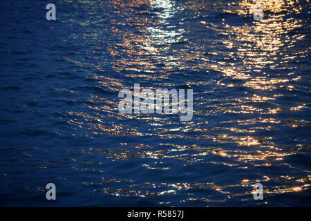 Fasci di luce sull'acqua durante il crepuscolo Foto Stock