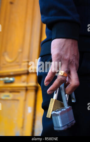 Un uomo ha di serrature di sicurezza in mano Foto Stock