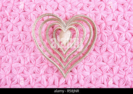 A forma di cuore ad albero di Natale decorazioni su maglia rosa tovagliolo. Foto Stock