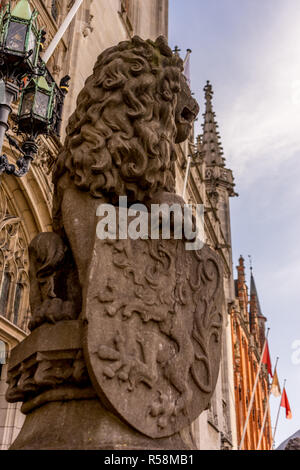 Belgio, Bruges, una statua di leone con scudo seduti sul lato di un edificio Foto Stock