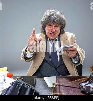 L'uomo anziano come detective o boss della mafia su grigio di sfondo per studio Foto Stock