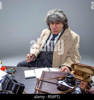 L'uomo anziano come detective o boss della mafia su grigio di sfondo per studio Foto Stock