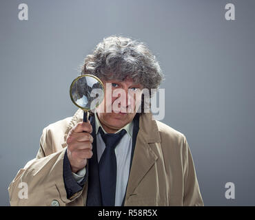 L'uomo anziano come detective o boss della mafia su grigio di sfondo per studio Foto Stock