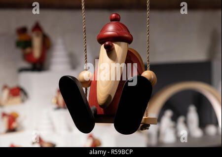 Il 30 novembre 2018, Schleswig-Holstein, Lubecca: un artista dalla regione di Erzgebirge presenta a tornire l'arte nella forma di un Babbo Natale sul swing al mercatino di Natale in Heiligen-Geist-ospedale. Il mercato artigianale nel XIII secolo sulle pareti è aperta fino al 10 dicembre. Foto: Rainer Jensen/dpa Foto Stock