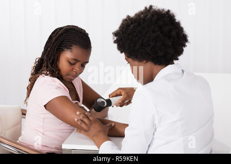 Il dermatologo controllo del bambino la pelle del paziente Foto Stock