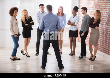 Manager di conversazione con i suoi colleghi di lavoro Foto Stock