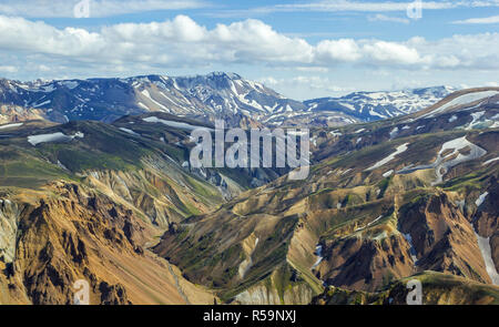 Colorate di alta montagna cresta vista con un picchi coperti di neve dal vertice della montagna Blahnakur, Landmannalaugar, Islanda Foto Stock