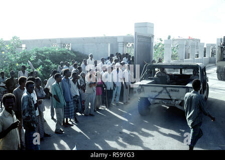 1992 - somali guardare come un M-998 veicolo di serie entra la Joint Task Force Somalia quartier generale. La sede è stata istituita presso l'ex U.S. Embassy composto durante la multinazionale soccorsi Restore Hope. Foto Stock