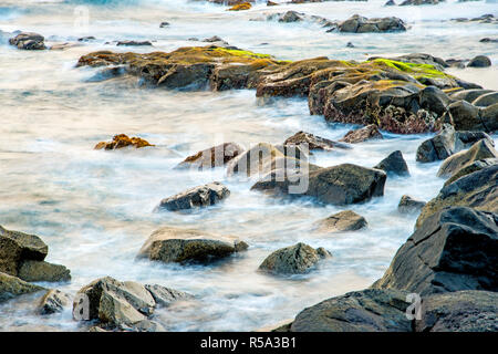 Surf dell'oceano Atlantico con rocce in una lunga esposizione Foto Stock