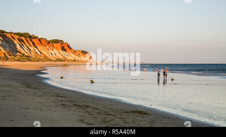 La gente a piedi sulla spiaggia Praia Falesia nei pressi di Albufeira Foto Stock