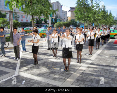 Xian, Cina - 10 Luglio 2010: uniformata lavoratori cinesi che esercitano in strada al mattino. Foto Stock