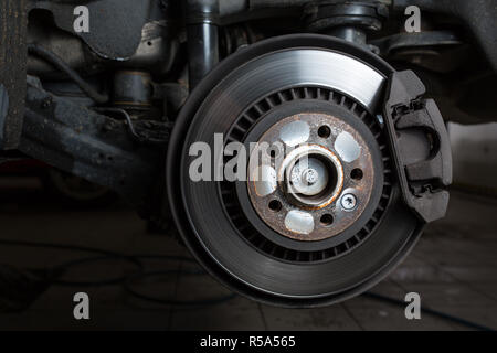 All'interno di un garage - moderna auto in attesa per il meccanico per cambiare le sue ruote/pneumatici (SHALLOW DOF dai toni di colore immagine) Foto Stock