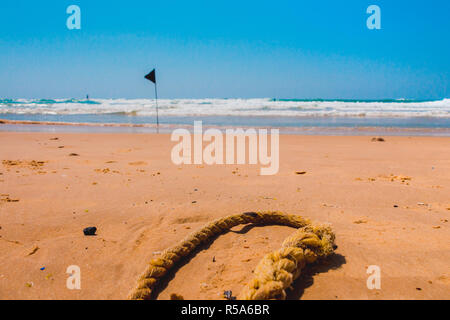 Black Flag di avviso che segna il limite della safe area nuoto su una bellissima spiaggia con cielo blu e un mare turchese in Israele Foto Stock