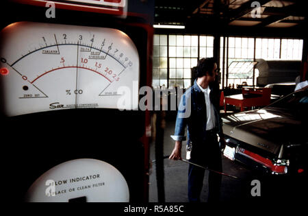 Primo piano di un analizzatore di gas di scarico utilizzato in corrispondenza di un'emissione automatica stazione di ispezione nel centro cittadino di Cincinnati, Ohio. Un dipendente della città in background sta tenendo il tubo flessibile che va dal auto della tubazione di scarico della macchina in cui si registra il monossido di carbonio e le emissioni di idrocarburi. Foto Stock