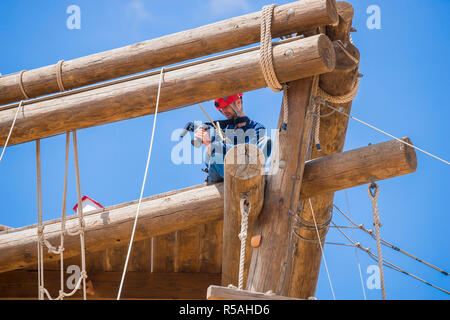 Extreme videografo professionista durante le riprese su torre scalare che funzionano in condizioni estreme Foto Stock