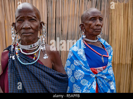 Due vecchie Masai donne in abito tradizionale e indossa gioielli tradizionali tra cui orecchini bracciali e collane Foto Stock