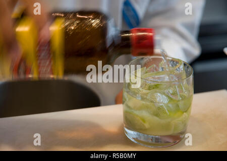 Barman versando cachaça alcol per prendere un drink di Caipirinha, Brasile del cocktail nazionali. Rio de Janeiro, Brasile Foto Stock