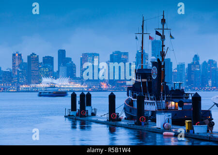 Canada, British Columbia, North Vancouver, Porto di Vancouver, vista città di Vancouver con rimorchiatore a traino e Sea Bus traghetto, crepuscolo Foto Stock