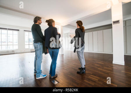 Giovane visitando un loft con un agente immobiliare. Foto Stock
