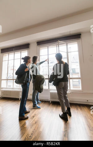 Giovane visitando un loft con un agente immobiliare. Foto Stock