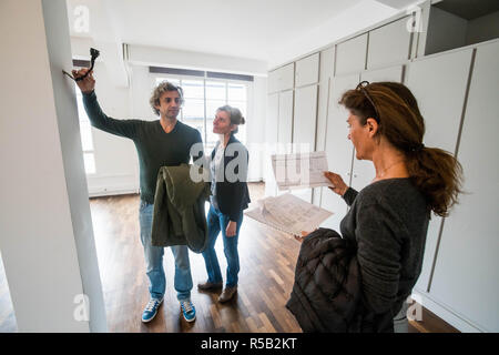 Giovane visitando un loft con un agente immobiliare. Foto Stock