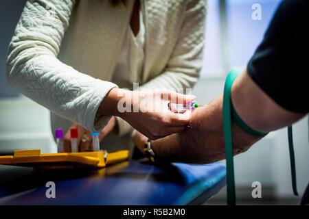 Infermiera liberale tenendo il campione di sangue da un paziente. Foto Stock