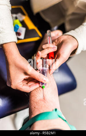 Infermiera liberale tenendo il campione di sangue da un paziente. Foto Stock
