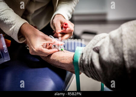 Infermiera liberale tenendo il campione di sangue da un paziente. Foto Stock