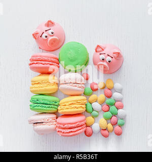 Il marzapane a forma del simbolo del nuovo anno - rosa maiale, dolce e delicato amaretti, marshmallows, arachidi zucchero in colori pastello su una luce posteriore Foto Stock