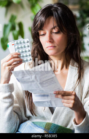 Donna medicina leggere il foglio di istruzioni. Foto Stock