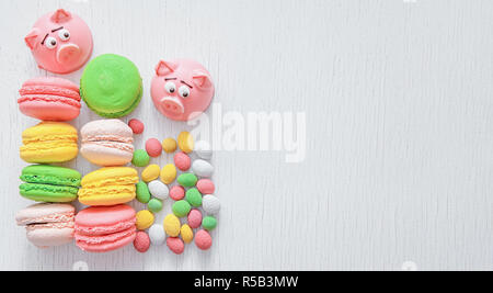 Il marzapane a forma del simbolo del nuovo anno - rosa maiale, dolce e delicato amaretti, marshmallows, arachidi zucchero in colori pastello su una luce posteriore Foto Stock