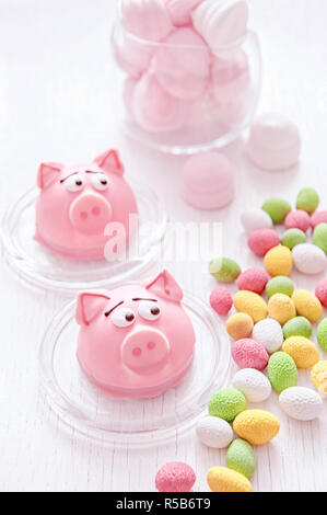 Il marzapane a forma del simbolo del nuovo anno - rosa maiale, dolce e delicato amaretti, marshmallows, arachidi zucchero in colori pastello su una luce. Foto Stock