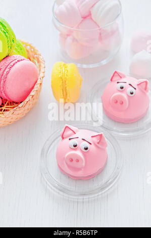 Il marzapane a forma del simbolo del nuovo anno rosa - maiale, dolce e delicato amaretti, marshmallows, arachidi zucchero in colori pastello su una luce posteriore Foto Stock