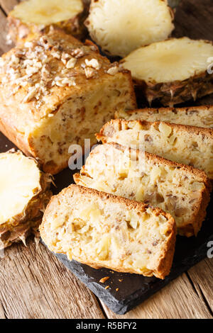 Pane appena sfornato di ananas a fette di pane con noci vicino sul piano verticale. Foto Stock