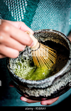 Donna preparazione matcha, polvere di tè verdi giapponesi Foto Stock