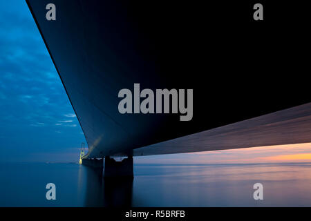 Crepuscolo sopra l'Est illuminato Bridge come visto da Korsor, Danimarca. Foto Stock