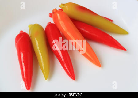 Rosso vibrante e di colore arancione a forma di peperoncino Kanom guardare Choup, tailandese tradizionale eliminabili imitazione Dessert di frutta Foto Stock