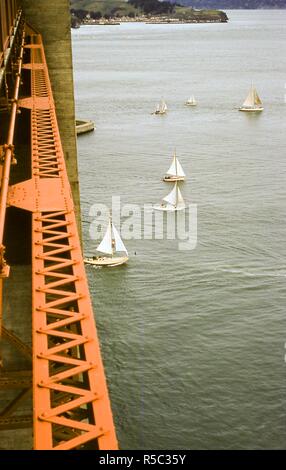 Vista delle barche a vela da crociera sotto il Golden Gate Bridge a est nella Baia di San Francisco durante il pacifico Inter-Club Yacht Association (PICYA) il giorno di apertura della baia di parata, a San Francisco, California, 30 aprile 1955. A bordo superiore rivolto verso il nord è Fort Baker, come si vede dalla strada pedonale sul lato orientale del ponte appena al di sopra del Fort Point. () Foto Stock