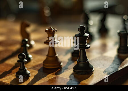 La regina e il re: scacchi pezzi su un bordo. La regina bianca si accoppia il re nero in un gioco di scacchi. Foto Stock