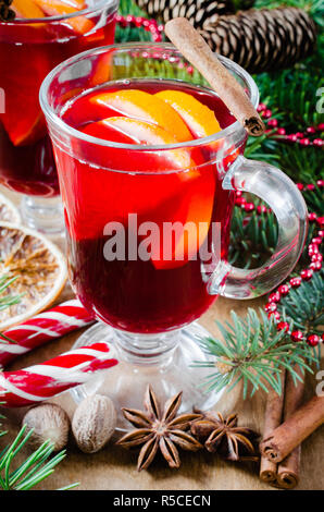 Vin brulé, spezie e albero di Natale rami su sfondo di legno. Cartolina di Natale. Disegnate la caduta della neve effetto. Messa a fuoco selettiva. Foto Stock