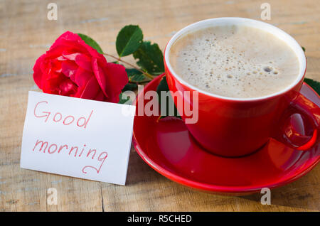 Tazza da caffè con Red Rose fiore e note di buona mattina su legno tavolo rustico da sopra, prima colazione sulle madri giorno, Womens giorno o il giorno di San Valentino Foto Stock
