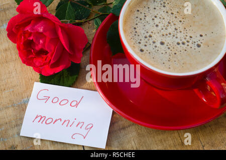 Tazza da caffè con Red Rose fiore e note di buona mattina su legno tavolo rustico da sopra, prima colazione sulle madri giorno, Womens giorno o il giorno di San Valentino Foto Stock