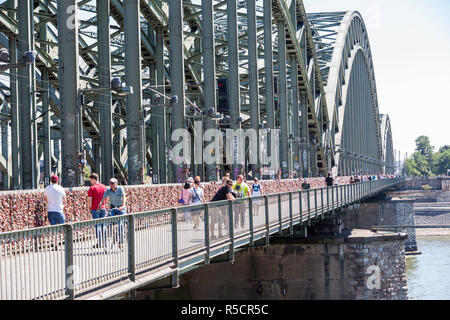 Colonia, Germania. Hohenzollern Ponte sul Reno, una stazione ferroviaria e il ponte pedonale, il piu' trafficato ponte ferroviario in Germania. Foto Stock