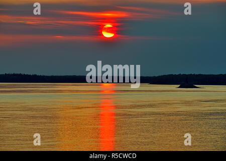 Tramonto attraverso forest fire haze oltre il Fiume MacKenzie, Fort Providence, Northwest Territories, Canada Foto Stock