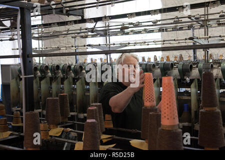 La Scozia, New Lanark, Donna filettatura di regolazione sul mulo di filatura macchina Foto Stock
