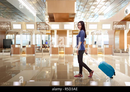 Giovane donna asiatica passeggeri con bagagli Foto Stock