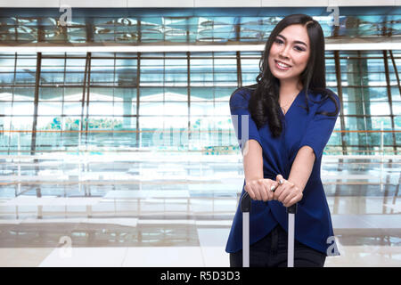 Bella donna asiatica in piedi con la valigia Foto Stock